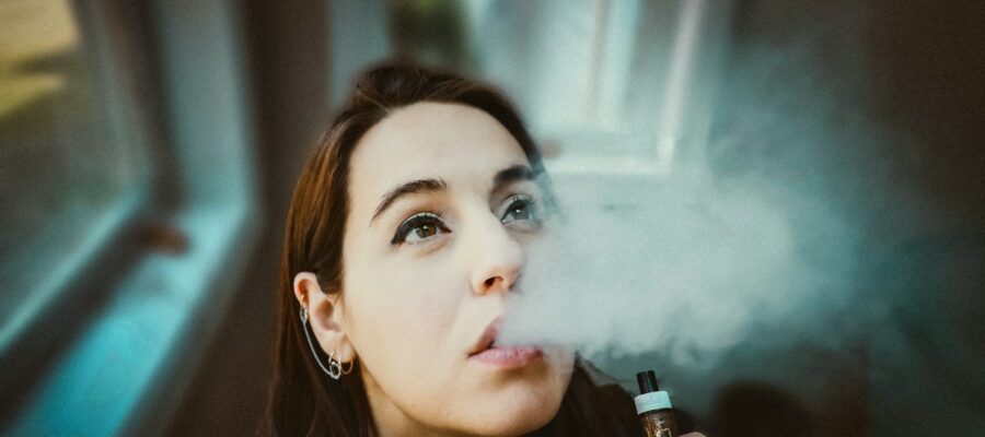 woman holding black and gold tube type vape